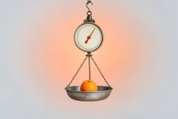 A hanging produce scale with an orange needle and a single orange resting in its metal pan, on a warm peach gradient.